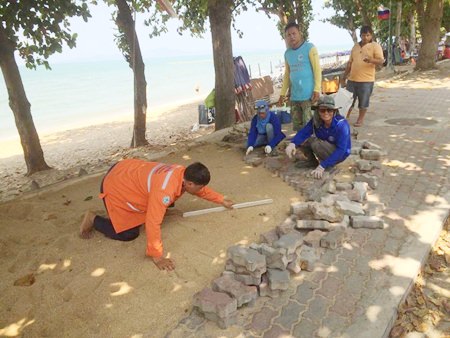 City workers filled in a 10-meter-long hole and built a cement retaining wall to prevent erosion, then laid bricks to complete the path at Yim Yom Beach.