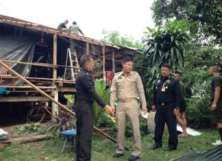 Officials inspect the damage as soldiers begin to repair a damaged roof on Koh Chan.