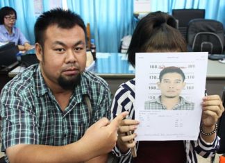 Reporter Klitichai Sapaklit points to a photo of Hathapong Hintua, wanted for sexual harassment of his girlfriend (holding photo).