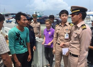 Ray (left) is interviewed by Navy officers after being pulled off a local fishing boat.