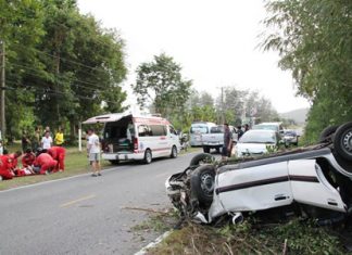 Medics administer aid to Warrant Officer Sapachai Chaimee (left) after he rolled his LPG-powered Mazda.