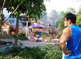 Noppong Srisai looks on as his house and all his belongings go up in smoke on Christmas Day.