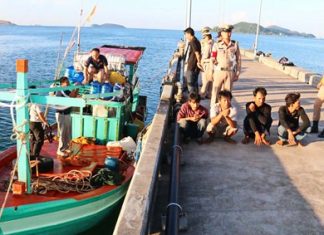 Captain and crew sit on a Thai Navy dock as officials search their tiny vessel.