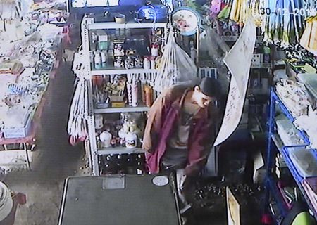 CCTV camera footage shows the suspect in the act of stealing a bag of cash from the shop.