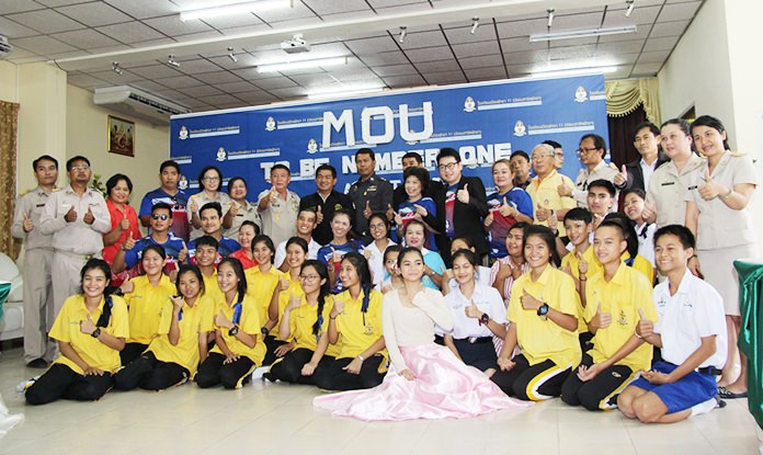 Students from Pattaya School 11 pose for a group photo with members of the World Vison Foundation and local police and communities after signing an agreement to help battle drug use.