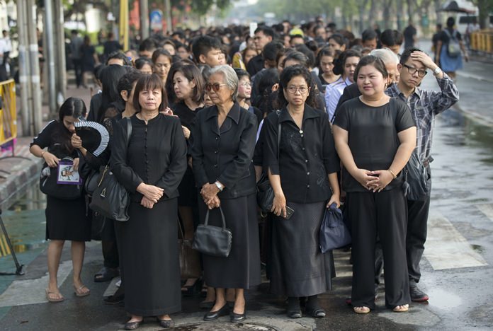 Thai people stand in lines to offer condolences for HM King Bhumibol Adulyadej at Grand Palace in Bangkok, Friday, Oct. 14. Grieving Thais went to work dressed mostly in black Friday morning, just hours after the palace announced the death of their beloved King, the the world’s longest-reigning monarch. (AP Photo/ Gemunu Amarasinghe)