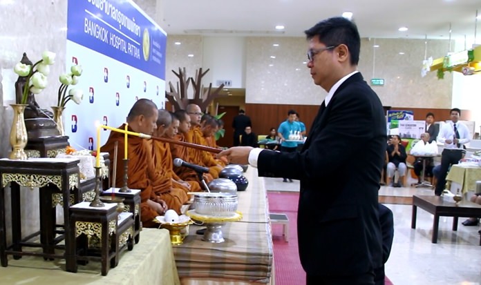 Director Pichit Kangwolkit leads the lighting of candles and incense in the “ratanattaya” worship service at Bangkok Hospital Pattaya.