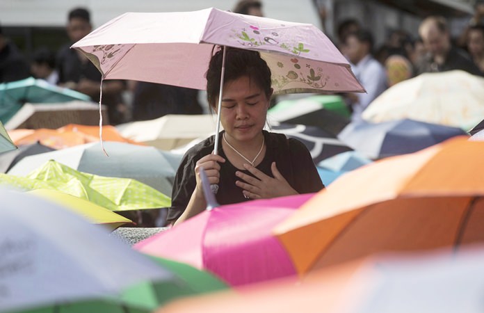 A Thai woman holds an umbrella as she waits to pay last respects to the late HM King Bhumibol Adulyadej outside the Grand Palace. The United Nations paid tribute to the late HM King Bhumibol Adulyadej on Friday, Oct. 28, with a moment of silence and speeches in the General Assembly Hall. (AP Photo/Wason Wanichakorn)