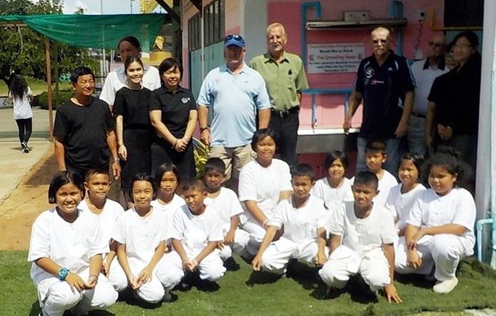 Children and teachers at Chumchon Ban Nongprue School pose for a photo with representatives from The Growling Swan golf bar.