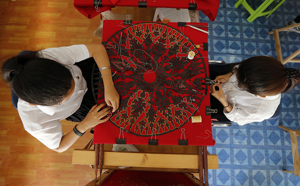 Women embroider intricate decorations for the royal crematorium. (AP Photo/Sakchai Lalit)