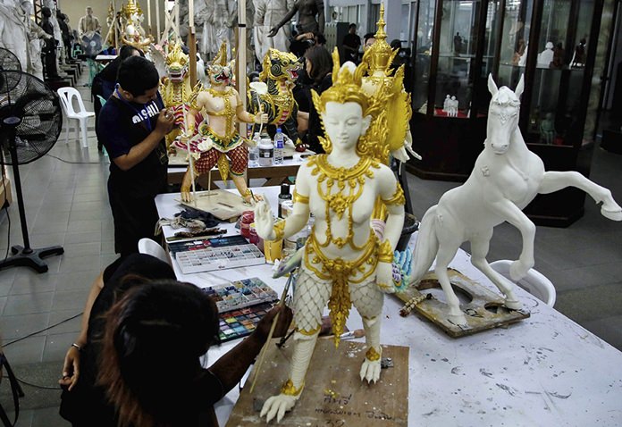 Volunteers paint statues of deities and creatures from ancient Indian epics to decorate the royal crematorium at the Fine Arts Department in Bangkok.