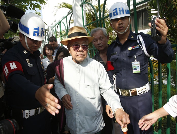 Sulak Sivaraksa, center, walks outside a military court in Bangkok, Wednesday, Jan. 17. (AP Photo/Sakchai Lalit)