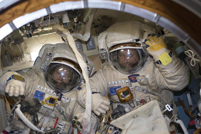 This Jan. 31, 2018 photo made available by NASA shows cosmonauts Alexander Misurkin, left, and Anton Shkaplerov in their Russian Orlan spacesuits during a fit check inside the International Space Station. On Friday, Feb. 2, 2018, the two removed an old electronics box as part of an antenna upgrade at the ISS, then tossed it overboard as a piece of junk. (NASA via AP)