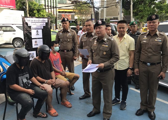 Ex-cop Vichai Kradkrayang and his accomplices sit at a news conference under the watchful eyes of Pol. Maj. Gen. Nantachart Supamongkol and Pol. Col. Appichai Kroppech.