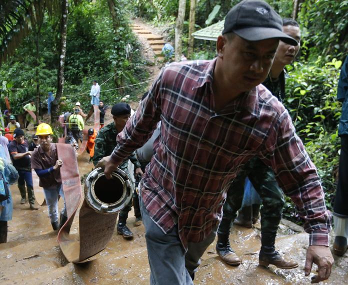 Rescue workers bring in large hoses and additional water pumps to continue the search for a young soccer team and their coach believed to be missing in a large flooded cave, Wednesday, June 27, 2018. (AP Photo/Sakchai Lalit)