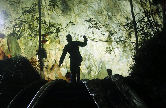 A rescuer makes his way down at the entrance to a cave complex where 12 boys and their soccer coach went missing, in Mae Sai, Chiang Rai province, in northern Thailand, Monday, July 2, 2018. (AP Photo/Sakchai Lalit)