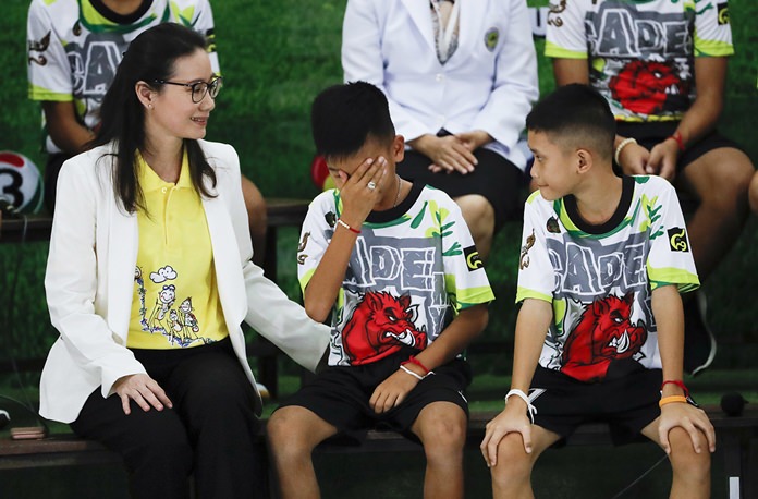 Rescued soccer player “Titan” Chanin Vibulrungruang reacts after paying respect to a portrait of Saman Gunan. (AP Photo/Vincent Thian)