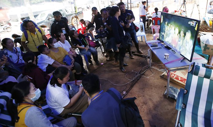 Family members of the 12 boys and their soccer coach watch a video clip of 12 boys on television after they were found alive, in Mae Sai, Chiang Rai province, in northern Thailand, Wednesday, July 4, 2018. Rescuers found all 12 boys and their soccer coach alive deep inside a partially flooded cave in northern Thailand.(AP Photo/Sakchai Lalit)