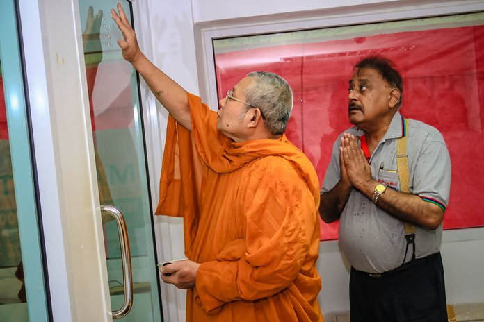 Pratheep Malhotra in deep contemplation as the revered head monk anoints his office with holy markings. 