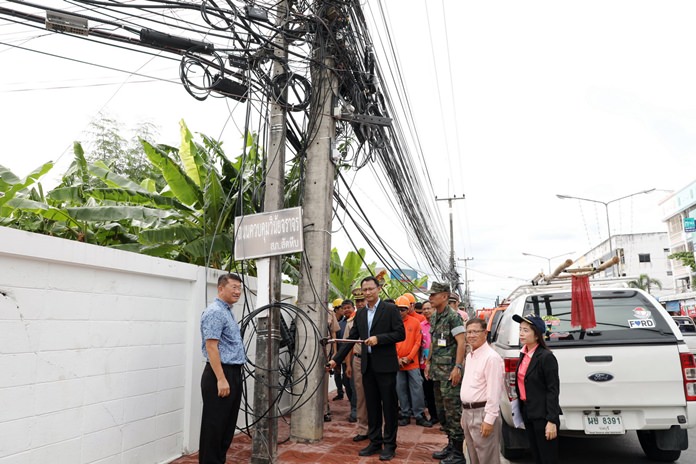 District Chief Auncha Intasorn and Sattahip Mayor Narong Bunbancherdsri pose for the cameras with wire cutters to begin tidying up chaotic power, television and internet lines in the city’s most-popular areas.