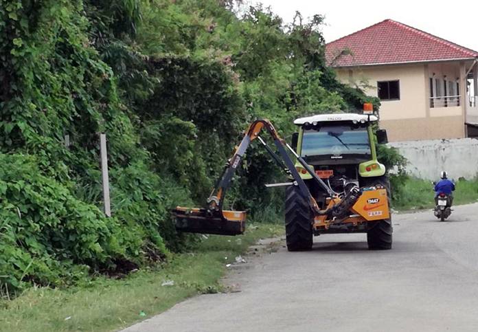 Nongprue workers prune trees and mow weeds at the Marbtato “little hill” intersection.