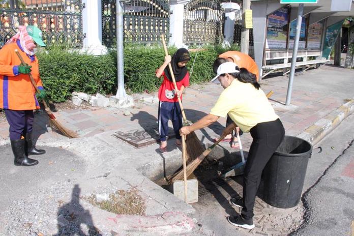 Residents in the Ton Krabok Community take part in a neighborhood cleanup, picking up trash and sweeping streets.