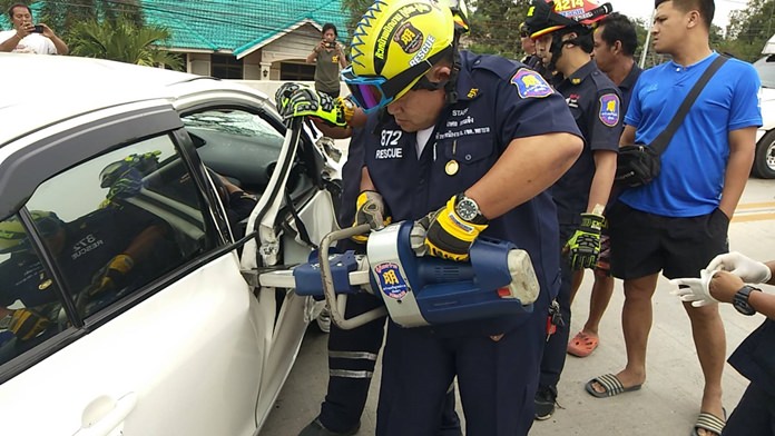 Rescue personnel use jaws-of-life to extricate an unidentified accident victim in Nongprue.