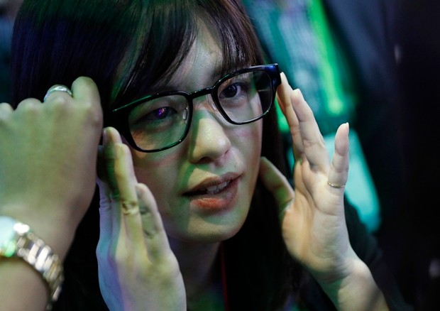 Yumi Dobashi tries on the Focals smart glasses at the North booth at CES International in Las Vegas. (AP Photo/John Locher)