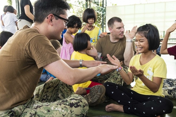 Lt. Mick Radiou, from Staunton, Va., and Gunner’s Mate 2nd Class Dylan McCurry, from Antioch, Ill., play games with children during a community service project at the Child Protection and Development Center in Chonburi.