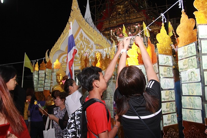 People take part in the sky robe offering ceremony at Wat Chaimongkol.