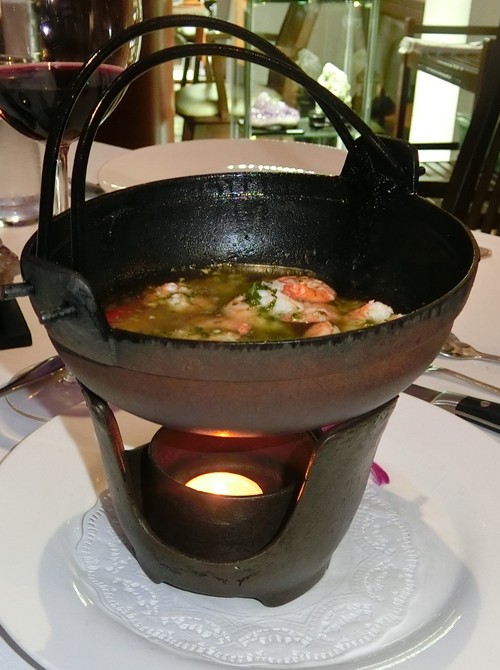 Garlic prawns in an iron pot.