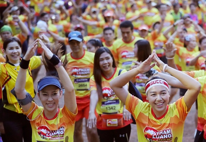 Runners warn up before the start of a marathon and biking event in Mae Sai, Chiang Rai province, Thailand, Sunday, June 23, 2019. (AP Photo/Sakchai Lalit)