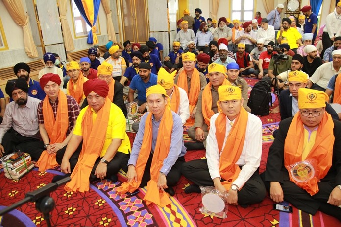 The minister together with city fathers and high-ranking government officials join the Sikh congregation in prayer and meditation.