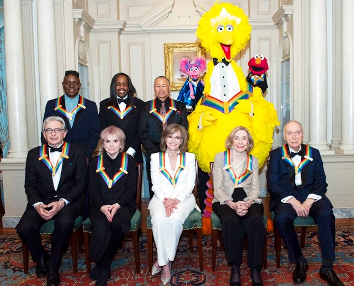 Front row from left, 2019 Kennedy Center Honorees Michael Tilson Thomas, Linda Ronstadt, Sally Field, Joan Ganz Cooney, and Lloyd Morrisett, back row from left, Philip Bailey, Verdine White, Ralph Johnson, and characters from "Sesame Street," Abby Cadabby, Big Bird, and Elmo pose for a group photo following the Kennedy Center Honors State Department Dinner at the State Department on Saturday, Dec. 7, 2019, in Washington. (AP Photo/Kevin Wolf)