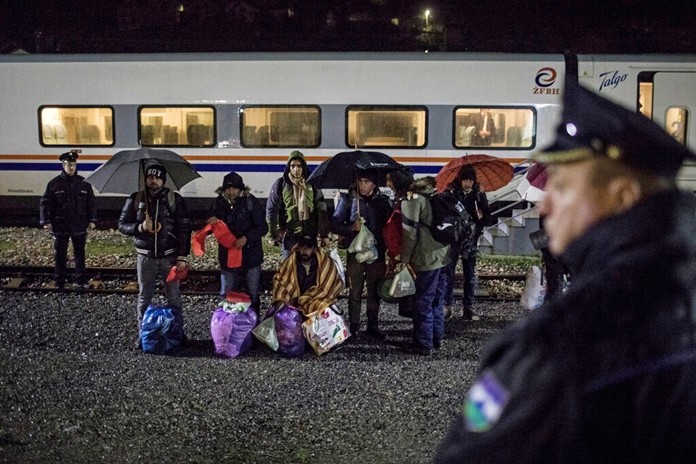 In this picture taken Saturday Dec. 14, 2019, a group of Pakistani migrants stands by the rail tracks after being taken off a train bound to the town of Bihac by Bosnian police in BosanskaKrupa, northwestern Bosnia. (AP Photo/Manu Brabo)