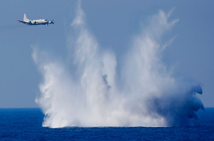 In this Oct. 18, 2015, file photo, a P-3C anti-submarine patrol plane of the Japan Maritime Self-Defense Force (JMSDF) flies after dropping anti-submarine bombs during the official triennial JMSDF fleet review in the waters off Sagami Bay, south of Tokyo. (AP Photo/Shizuo Kambayashi, File)