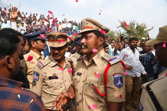 People throw flower petals on the Indian policemen guarding the area where rape accused were shot, in Shadnagar some 50 kilometers or 31 miles from Hyderabad, India, Friday, Dec. 6, 2019. (AP Photo/Mahesh Kumar A.)