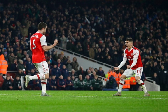 Arsenal's Sokratis Papastathopoulos, left, celebrates with teammate Lucas Torreira after scoring their side's second goal during the English Premier League soccer match between Arsenal and Manchester United at the Emirates Stadium in London, Wednesday, Jan. 1, 2020. Papastathopoulos scored once in Arsenal's 2-0 victory. (AP Photo/Matt Dunham)