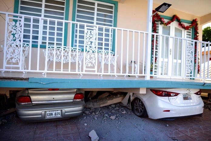 Cars are crushed under a home that collapsed after an earthquake hit Guanica, Puerto Rico, Monday, Jan. 6, 2020.(AP Photo/Carlos Giusti)