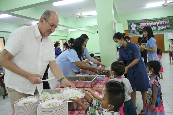 Denis Thouvard helps serve lunch to grateful children.