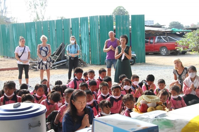 Khun Kru Pim, Principle of ASEAN Education Center leads, HHNFT executives and children in prayer.