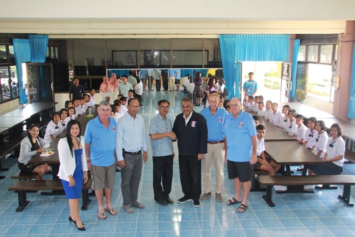 Peter Malhotra shakes hands with school director Apiwat Jaiyungyuen as PSC committee members Noi Emmerson, VP Tim Knight, Willem Lasonder and Stan Rees pose for a photo with students sitting at their new dining/all-purpose tables.