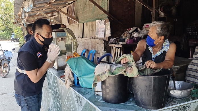 Dr. Satira Puakpraphan greets a villager and politely asks for permission to spray disinfectant in and around her home.