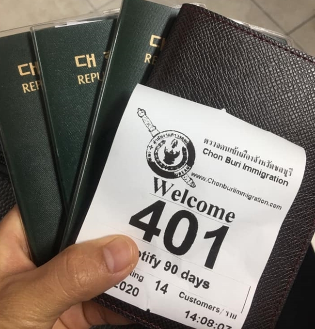 An unidentified messenger with a handful of passports shows the 90-day reporting ticket being handed out.