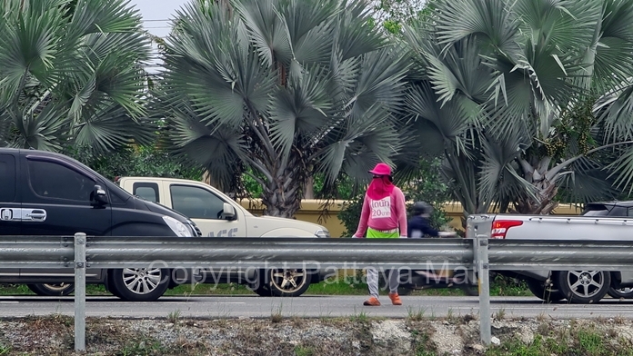 Pink shirted donut sellers dodge moving traffic when the lights turn green.