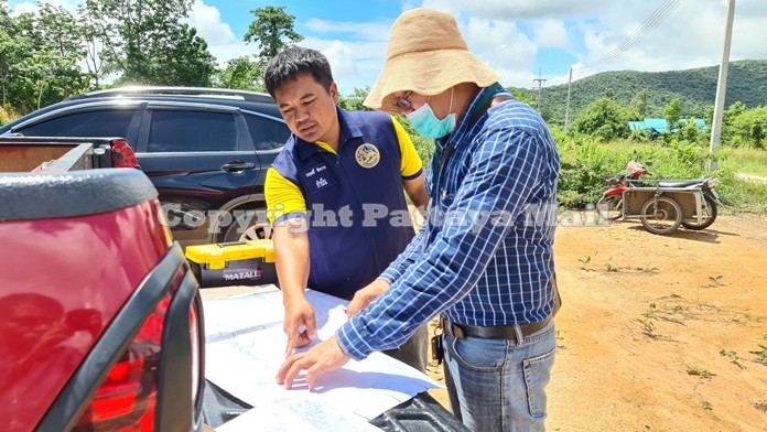 Worarit Jungbavorn, Bang Saray district headman and Somchok Siri, Surveyor from the Sattahip Land Department inspect a map to determine whether there was any encroachment on public land.