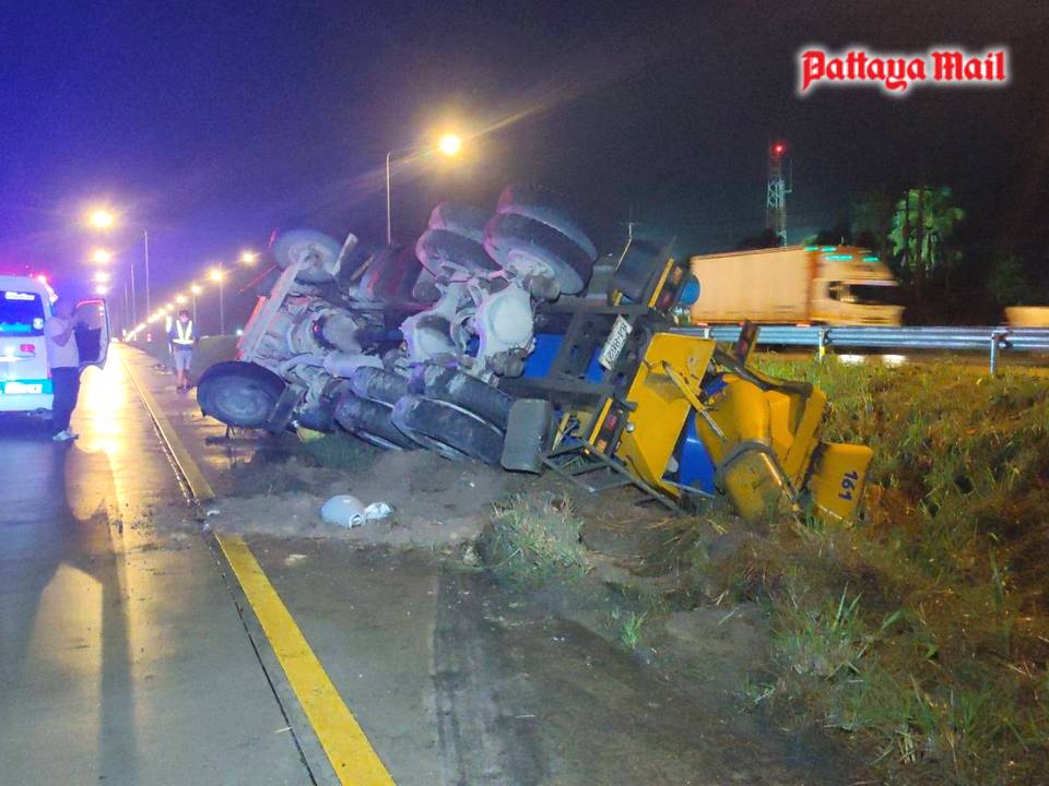 A cement truck lies on its side after skidding off Pattaya-Rayong Highway 36. The driver was unhurt.